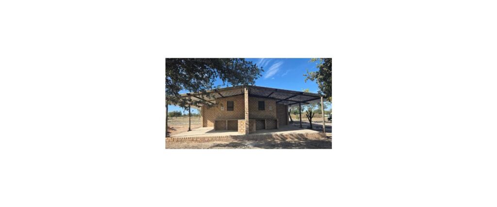 Exterior view of the brick farmhouse and covered patio at Tamboti Farm Camp Sites near Tsumeb