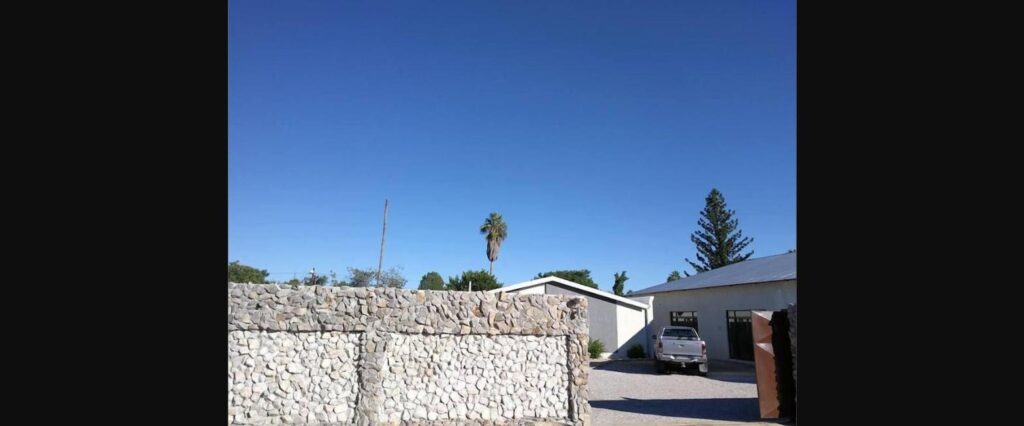 Exterior stone wall entrance of Tsumeb Guesthouse Kamho in Tsumeb, Namibia