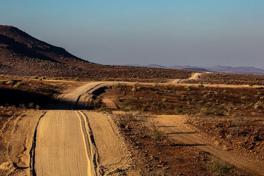 Etosha gate route represented by a long gravel road crossing an arid Namibian landscape